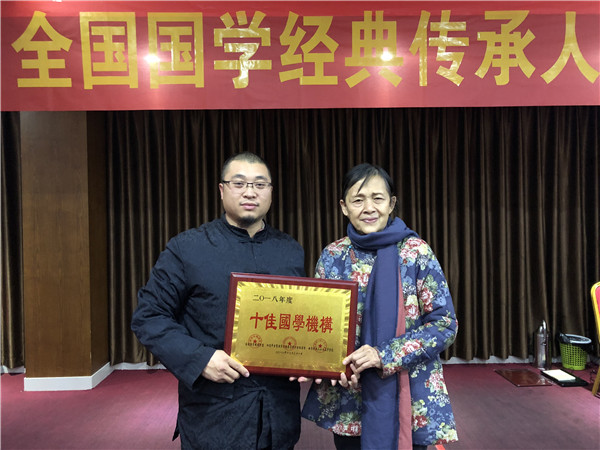 8、 廖延斌在2019年山东曲阜全国国学联盟机构年会上从世界家风大会组委会副主席廖小义(右)手中接过“年度十佳国学机构”奖牌(资料).jpg